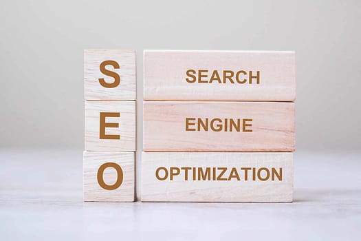 6 wooden blocks on a white background that spell SEO and search engine optimization